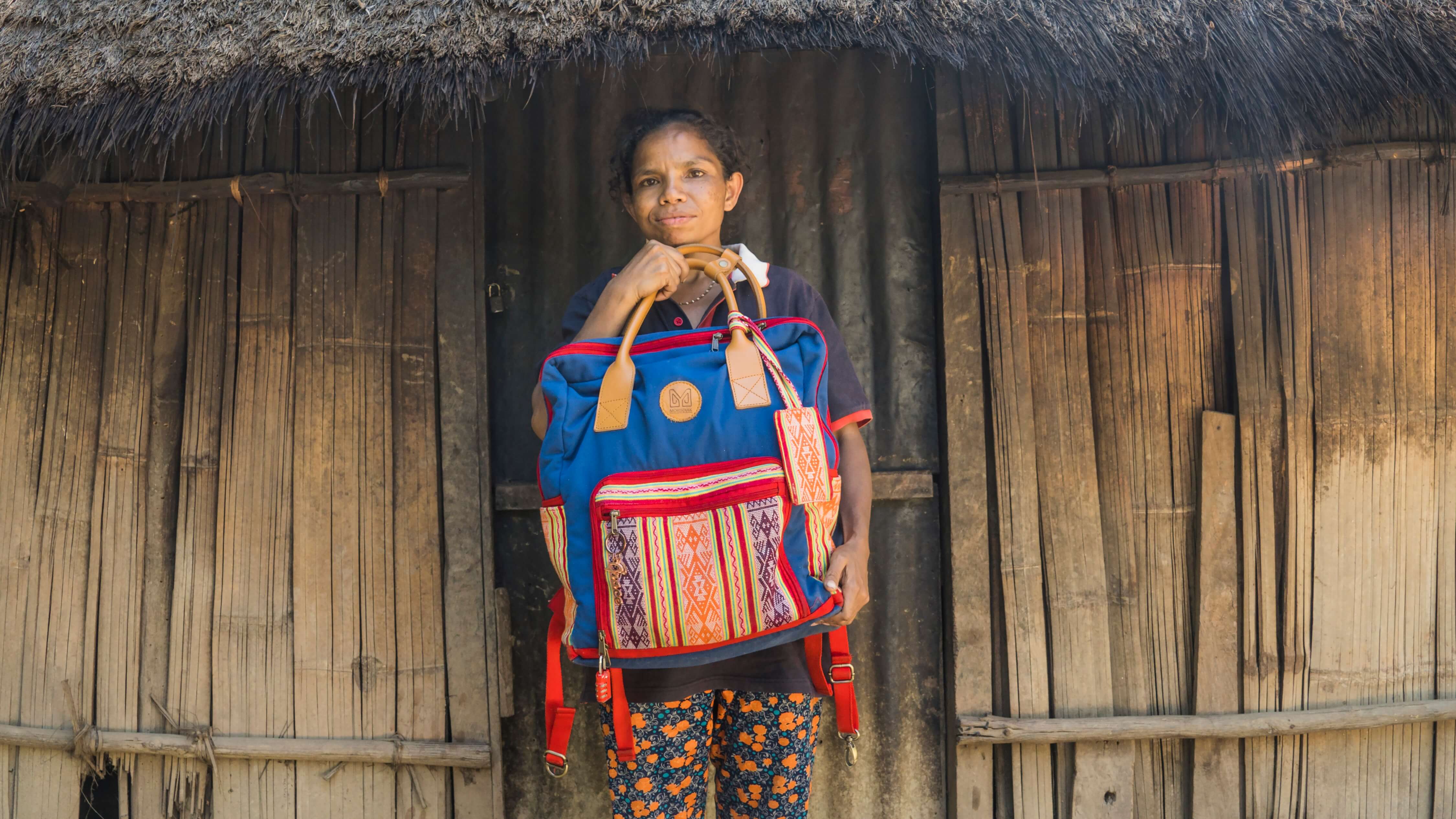 Amelia holds a tenun backpack from a Yogyakarta-based brand that partners with Lakoat.Kujawas to incorporate tenun into their pieces. The tenun is by Amelia.