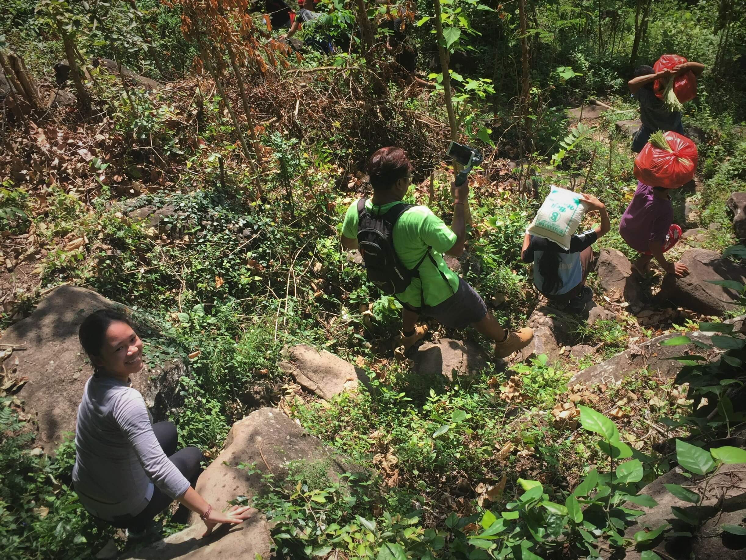 Santi (far left) making her way down a steep hillside path during a Feed Bali distribution run. Photo courtesy of Tresna Bali Cooking School 